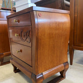 Vista laterale del comodino sagomato in legno ciliegio con pomelli in ottone, intaglio decorativo e gambe arcuate, collezione Arte Visconti Piombini